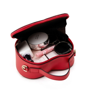 Macro shot of a red heart-shaped makeup bag showing spacious interior with cosmetics