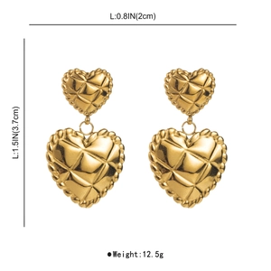 Macro detail of gold double heart earrings featuring quilted texture and dimensions