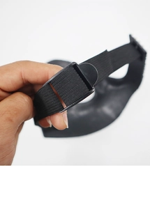 Detail of the adjustable black elastic strap and plastic buckle on a masquerade mask
