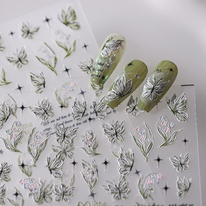 Detail of 3D embossed nail stickers featuring silver butterflies and green lily flowers