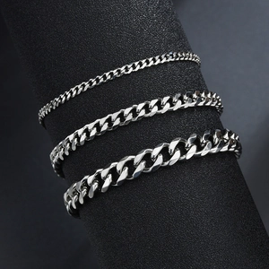 Three-piece set of silver Cuban chain bracelets in varying widths on a display stand