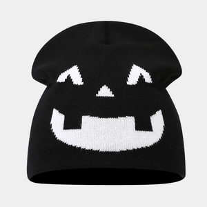 Detailed knit texture of black Halloween beanie featuring a white pumpkin face pattern
