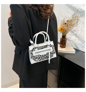 Chic handbag with white leather and leopard print panel worn with a black blazer