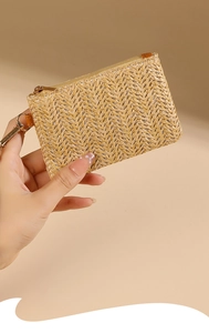 Close-up of beige woven coin purse with herringbone pattern and golden zipper detail