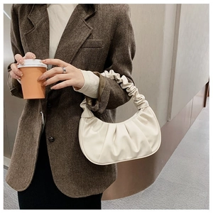 Dettaglio della borsa a mano plissettata bianco crema in pelle PU con manico