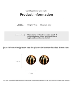 Detailed view of round ball stud earrings with black and gold enamel stripe texture