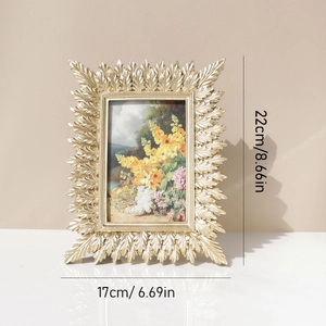 Golden leaf resin photo frame with 22x17cm external dimensions displayed on a clean surface