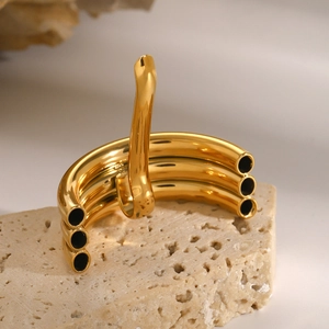 Macro detail of high-polish gold U-shaped hair fork on minimalist beige stone base