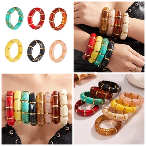 Detail view of colorful resin bamboo bracelets with gold spacers in various vibrant colors