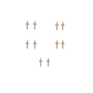 Macro view of ten rose gold cross pendants with sparkling zircons for DIY jewelry making