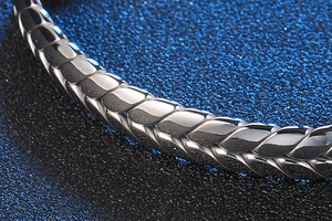 Primer plano de pulsera de acero inoxidable trenzado plateado con detalle de espiga