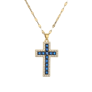 Gold necklace with blue zircon cross pendant and flat link chain on white background