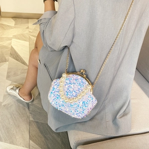Iridescent sequin mini bag with pearl handle and gold chain strap shown on model