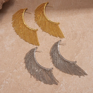 Elegant gold and silver beaded tassel hoop earrings with metallic texture on stone surface