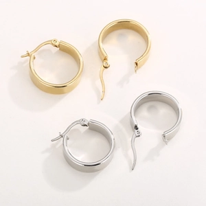 Close-up of minimalist stainless steel wide U-shaped hoop earrings in gold and silver
