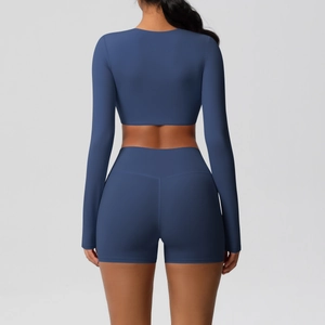 Detail view of seamless dark blue yoga set showing back of cropped long sleeve top and shorts