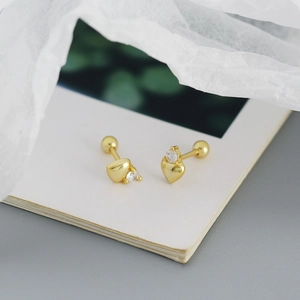 Macro shot of 925 silver heart stud earrings in gold with zircon and screw back closure