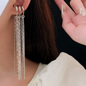 Close-up of silver tassel ear cuff earrings with multi-layer chains on model ear