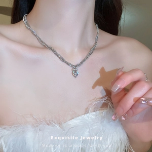 Exquisite silver multi-layer necklace with a zircon heart pendant and bow detail on model
