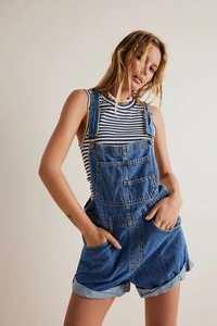 Close-up of light blue denim dungarees with large chest pocket and metal buckle detail