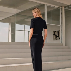Detailed knit texture of a black slim-fit maxi dress featuring a polo-style collar
