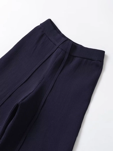 Detail of navy blue knit trousers waist featuring vertical texture and drawstring
