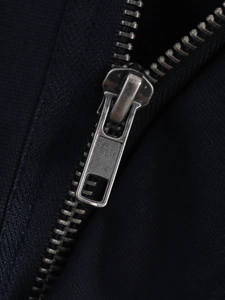 Macro detail of high-quality metal zipper and fabric texture on a fashion jacket