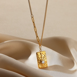 Macro shot of 18K gold plated hammered texture pendant with zircon on champagne silk