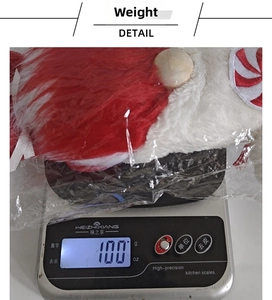 Detail showing Christmas faceless gnome weight of 100g on a scale for product specification