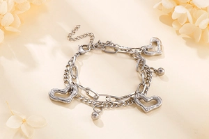 Détail d'un bracelet double couche en acier inoxydable avec pendentifs cœur et billes