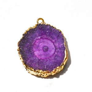 Macro view of purple agate slice pendant with electroplated gold edge and natural crystal textures