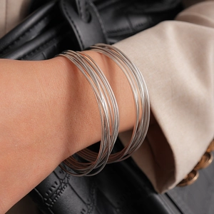 Stackable silver thin wire bangle set on wrist with chic polished finish look