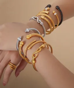 Détail de bracelets et bagues torsadés multicolores avec finitions or, argent et noire