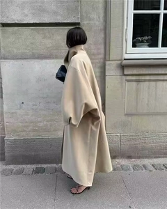 Close-up of beige oversized wool coat featuring a mock neck and drop shoulder design