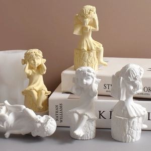 Detailed view of angel girl silicone molds for handmade resin ornaments on a log base