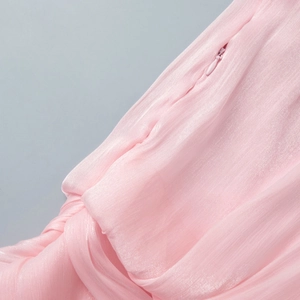 Macro shot of invisible zipper detail on pleated pink chiffon dress with silk luster