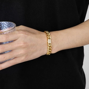 Mens gold-plated Cuban link necklace with iced-out CNC diamond clasp worn by model