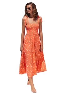 Close-up of orange polka dot dress featuring smocked bodice and tiered ruffle hem details