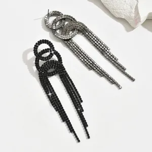 Macro shot of elegant long tassel drop earrings in black and gunmetal with sparkling crystals