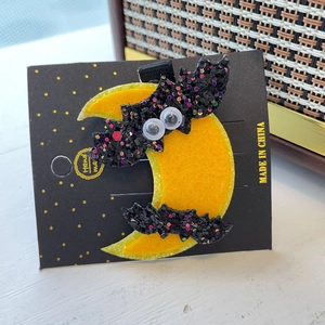 Detail of Halloween sequin bat and moon hair clips on handmade display card