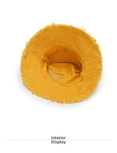 Detail view of the yellow bucket hat interior showing frayed edges and embroidery