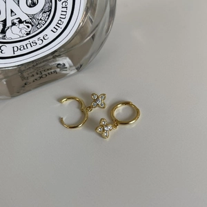 Detailed close-up of gold-plated silver cross earrings with clear zircon stones