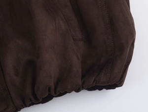 Detailaufnahme der dunkelbraunen Wildlederjacke mit elastischem Saum und Nähten