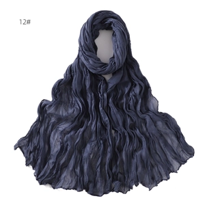 Detail shot of navy blue lightweight scarf with pleated texture and wavy fabric patterns