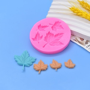 Round pink silicone maple leaf mold with finished blue and brown fondant leaves