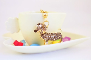 Gros plan d'un porte-clés teckel doré avec cristaux bruns sur une tasse jaune