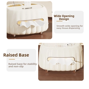 Detailed view of cream-colored tissue box with wide opening and gold-tone elevated feet