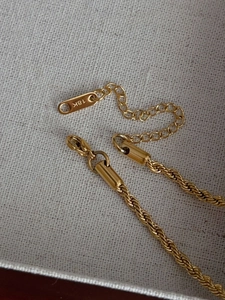 Detailed close-up of 18k gold-plated titanium steel rope chain with secure lobster clasp
