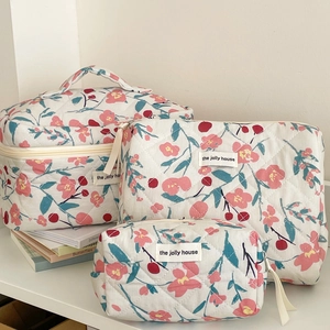 Three sizes of floral quilted cotton makeup bags with pink blossoms and green leaves