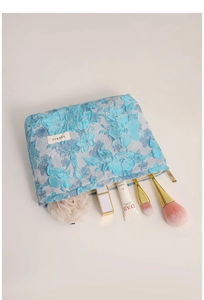 Blue floral lace makeup bag showing interior storage for cosmetics and brushes